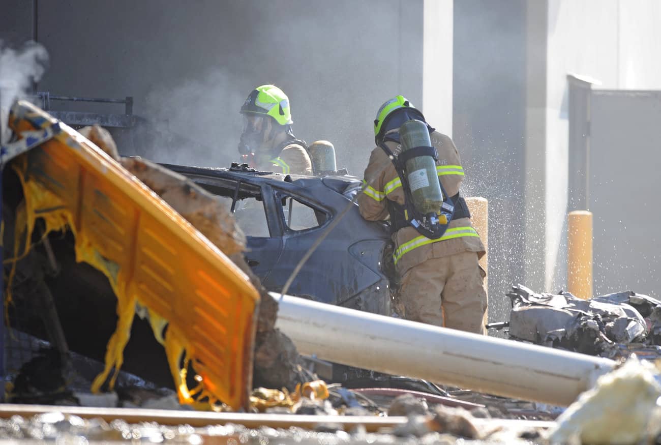 Emergency services personnel are seen at the scene of a plane crash in ...