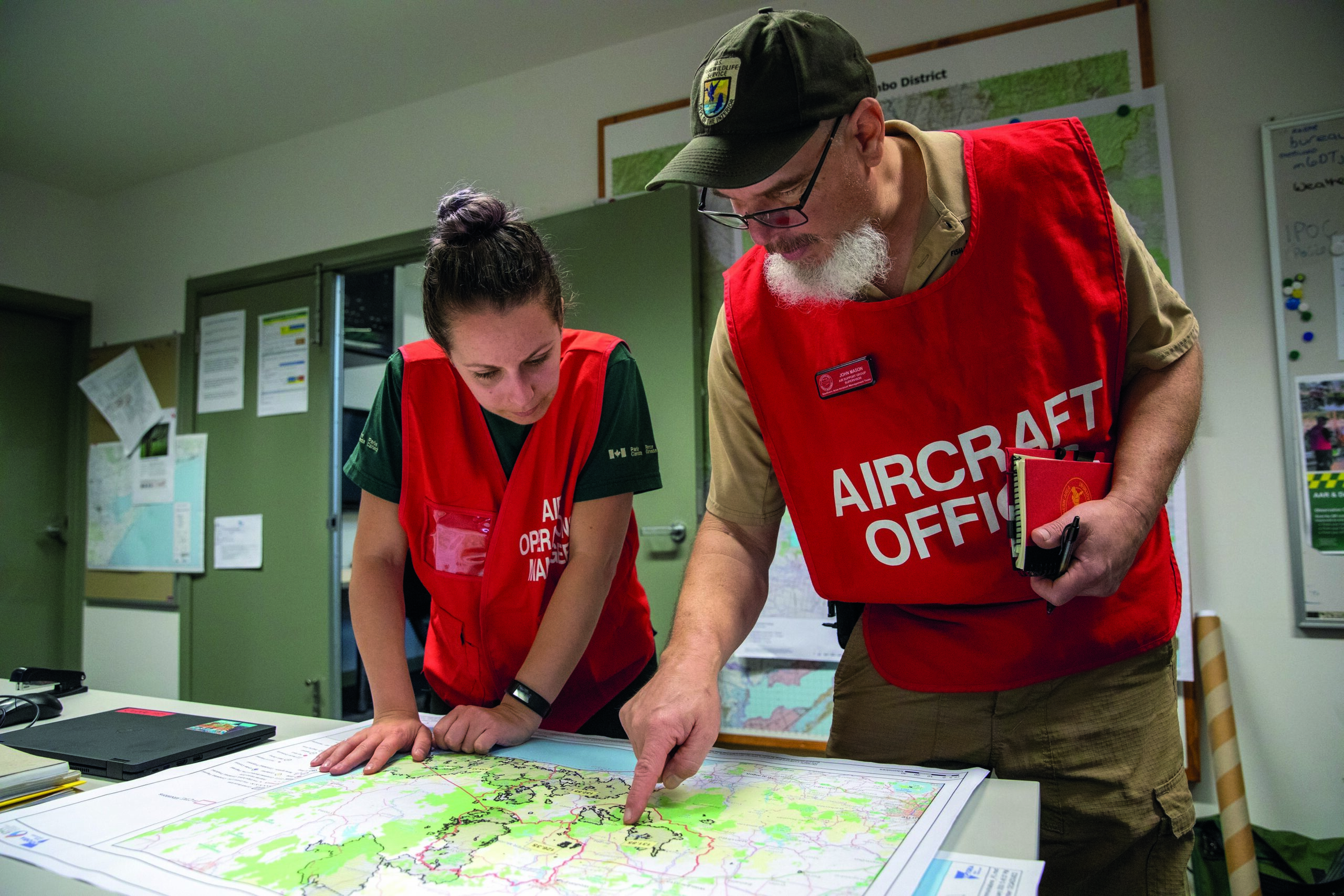 Aircraft Officers from Parks Canada and the US Fish & Wildlife Service discuss upcoming operations at the Bairnsdale Control Centre. 